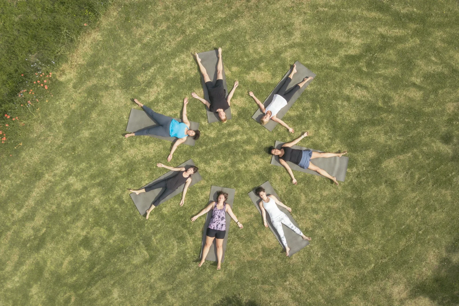 Women resting in a circle on their mats after practice